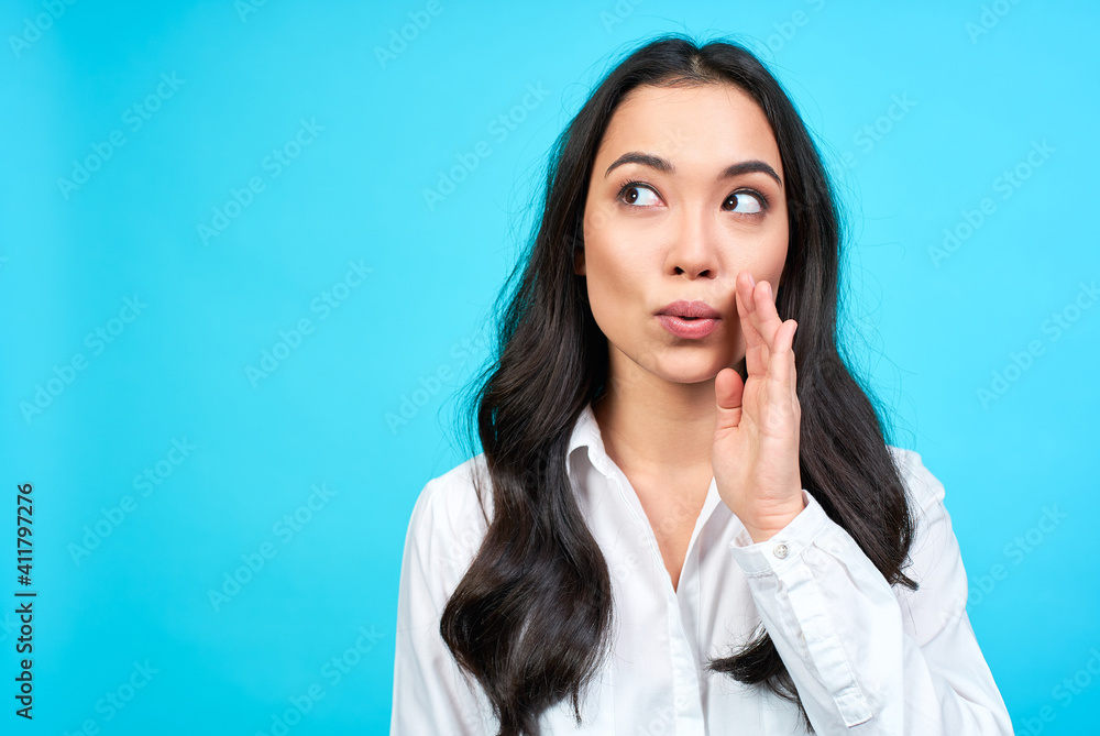 Asian girl whispers important information to you. Asian girl whispers important information to you.