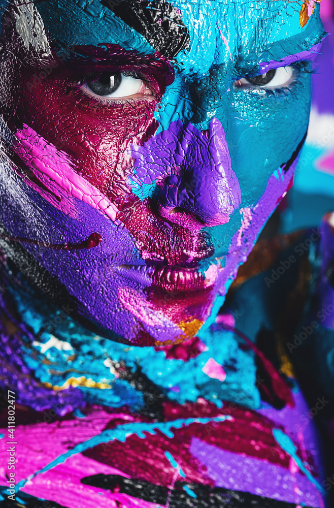 close up portrait of beautiful woman in blue and violet paint