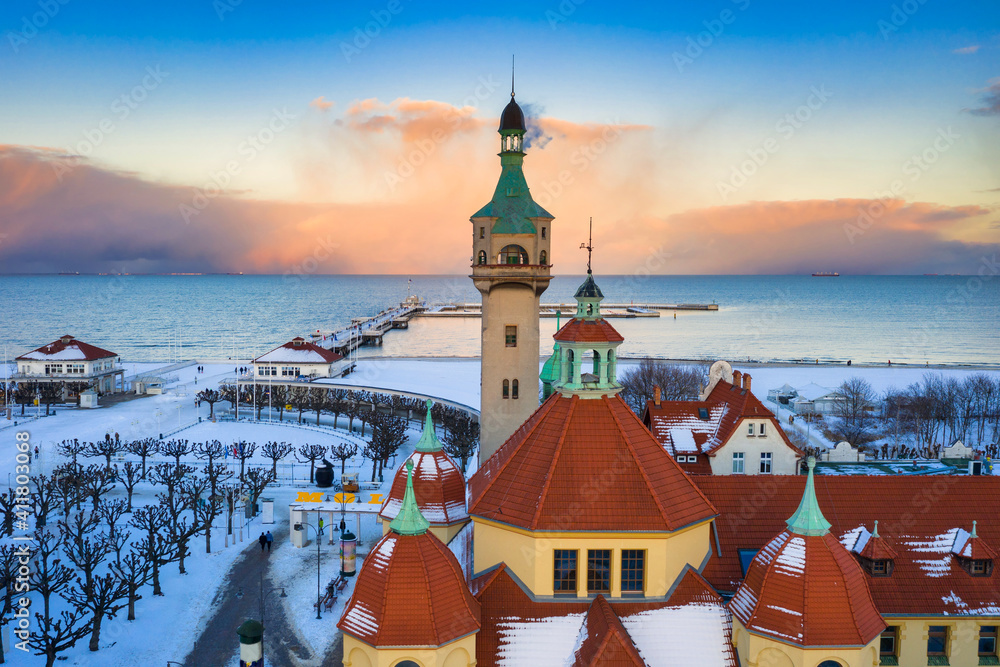Obraz premium Beautiful sunset over the snowy beach and pier (Molo) in Sopot at winter. Poland