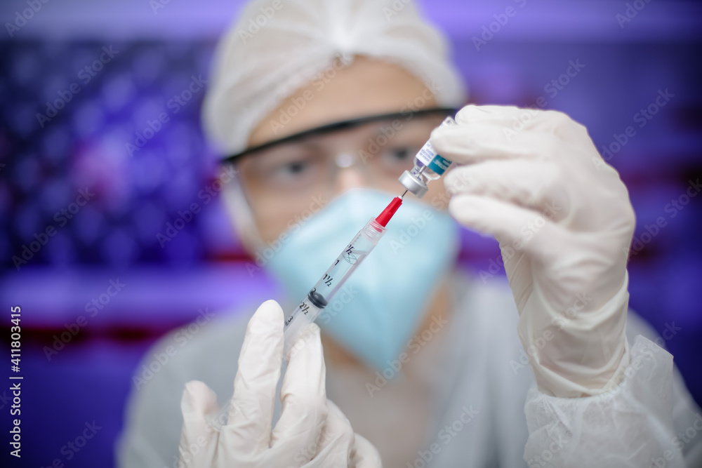 Medica segurando uma seringa de Vacina na prevenção de covid 19 com fundo obstrato e desfocado. Medica segurando uma seringa de Vacina na prevenção de covid 19 com fundo obstrato e desfocado.
