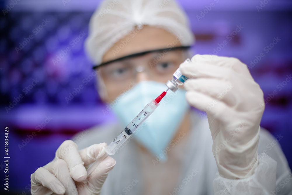 Medica segurando uma seringa de Vacina na prevenção de covid 19 com fundo obstrato e desfocado. Medica segurando uma seringa de Vacina na prevenção de covid 19 com fundo obstrato e desfocado.