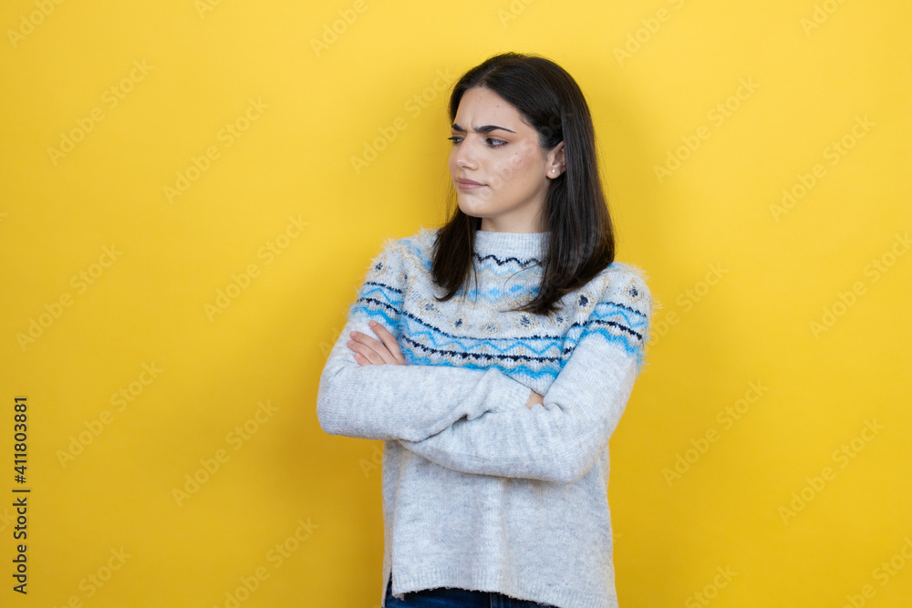 Young caucasian woman wearing casual sweater over yellow background thinking looking tired and bored with crossed arms Young caucasian woman wearing casual sweater over yellow background thinking looking tired and bored with crossed arms