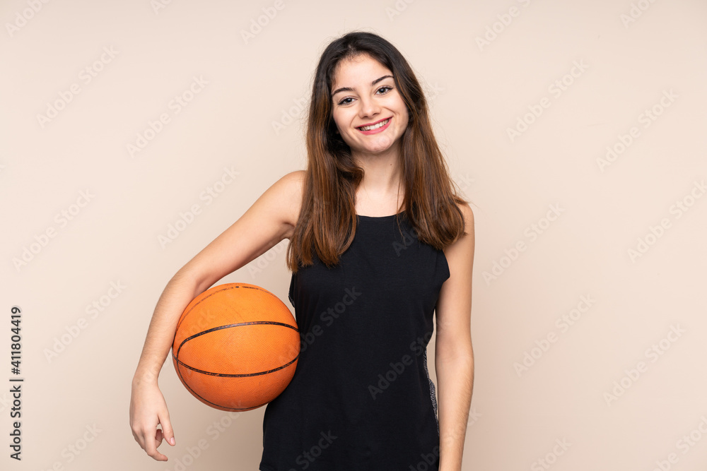 Young caucasian woman isolated on beige background playing basketball