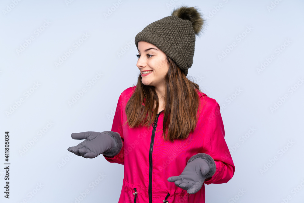 Young girl with winter hat isolated on blue background with surprise facial expression Young girl with winter hat isolated on blue background with surprise facial expression