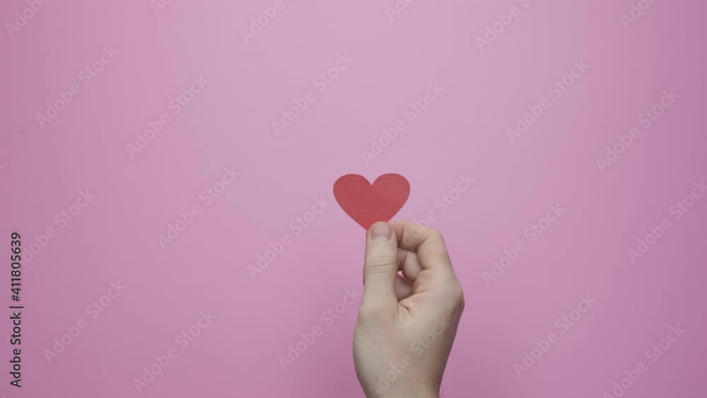 Dancing red heart on a colored background. Concept Valentine's Day February 14 Dancing red heart on a colored background. Concept Valentine's Day February 14