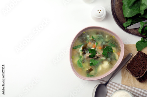 Delicious sorrel soup with meat and parsley served on white table, flat lay. Space for text