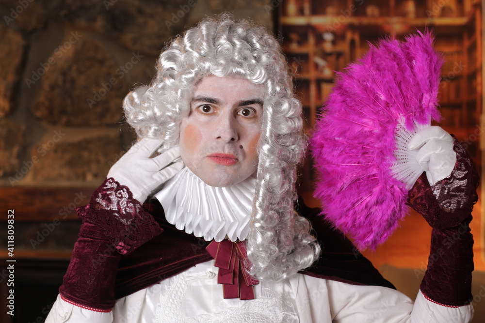 Pompous baroque man with pink feather hand fan