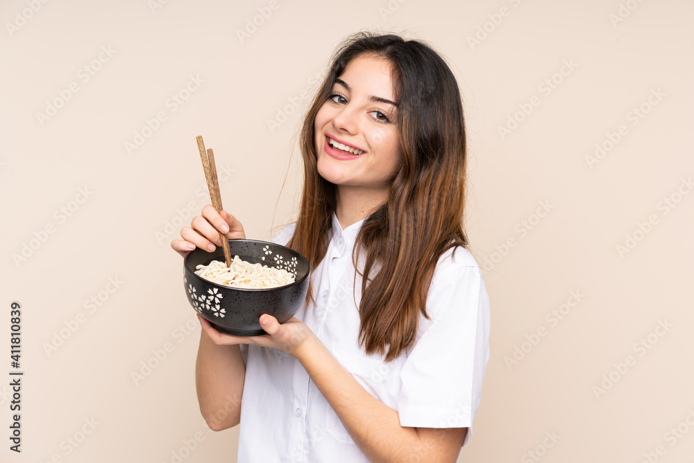 Girl holding a bowl full of noodles over isolated background Girl holding a bowl full of noodles over isolated background