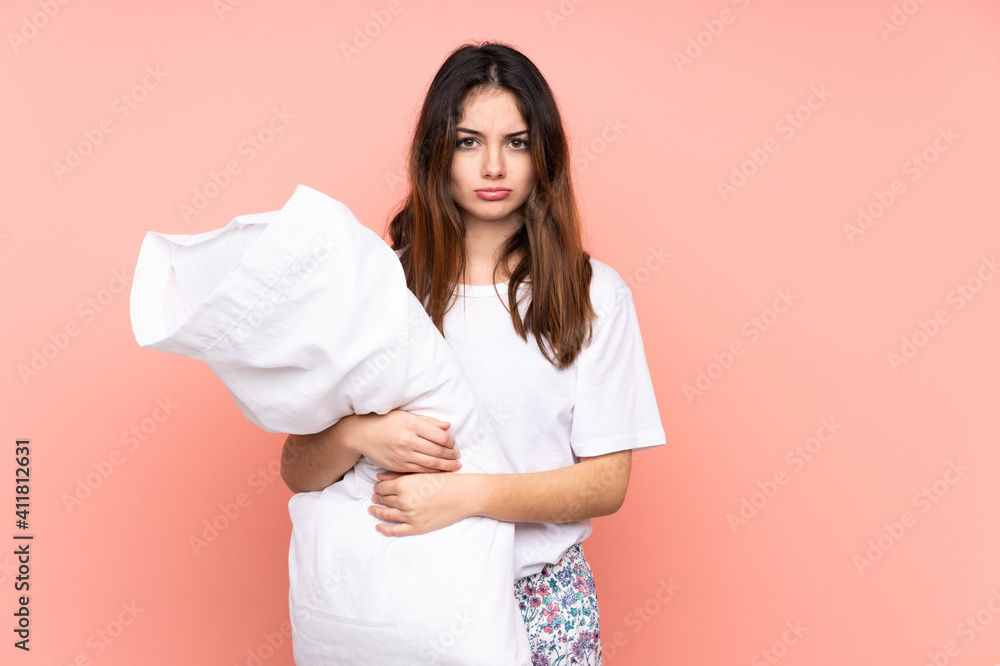 Young woman in pajamas isolated on pink background sad Young woman in pajamas isolated on pink background sad