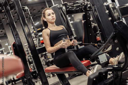 Fit woman exercising in a rowing machine in a modern gym