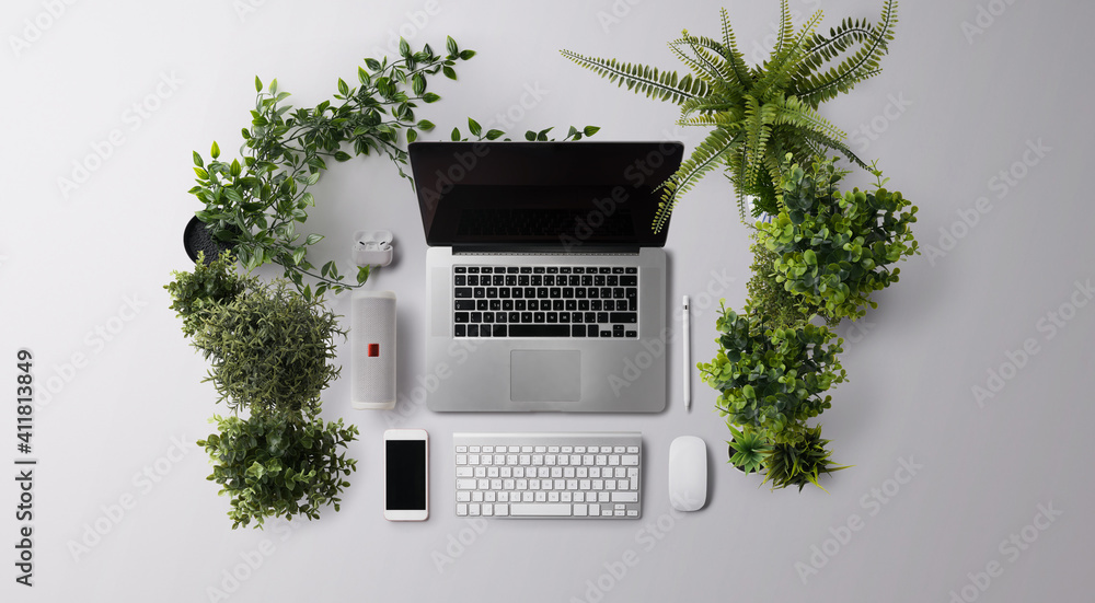 Fototapeta premium Flat lay top view office desk working space with laptop and supplies on gray background.