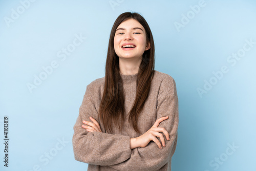 Young Ukrainian teenager girl wearing a sweater over isolated blue background keeping the arms crossed in frontal position © luismolinero
