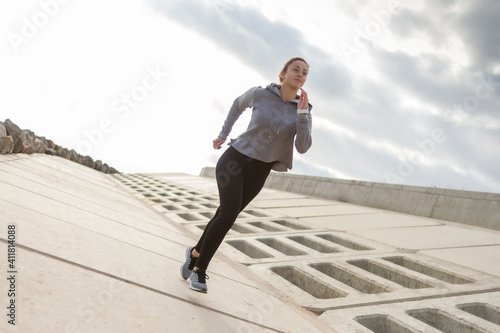 Sporty woman runner in sportswear jogging outdoors