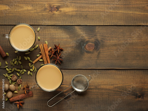 Photography Two mugs with masala tea stand on a wooden table with spices
