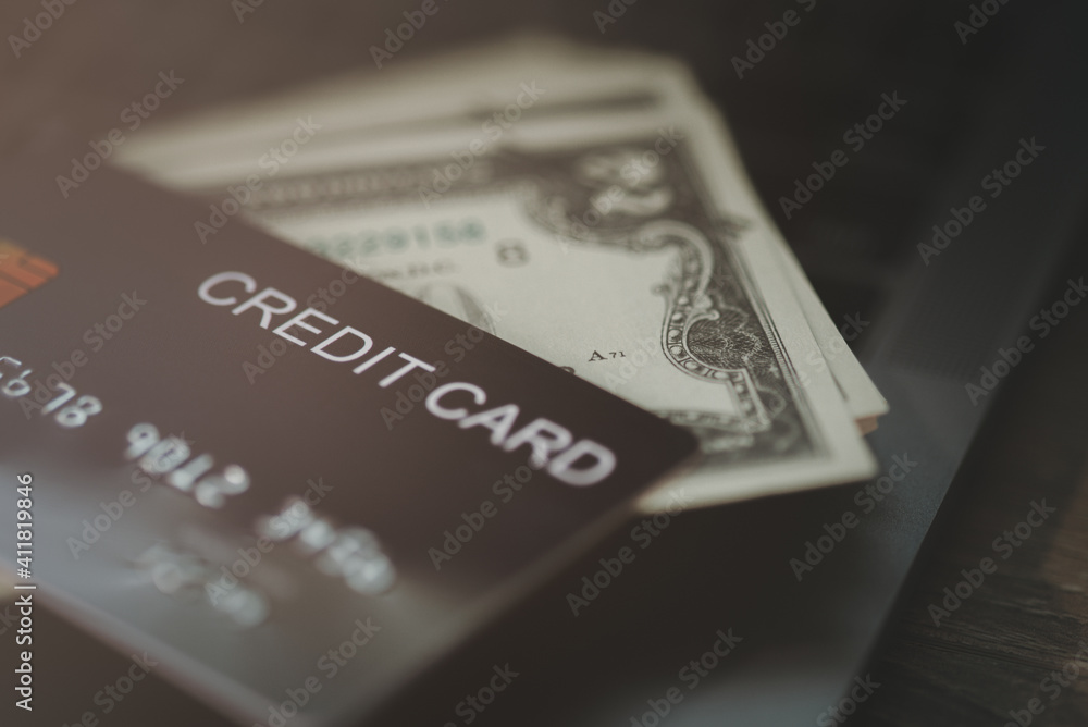 The credit card is placed on top of the dollar bill The credit card is placed on top of the dollar bill