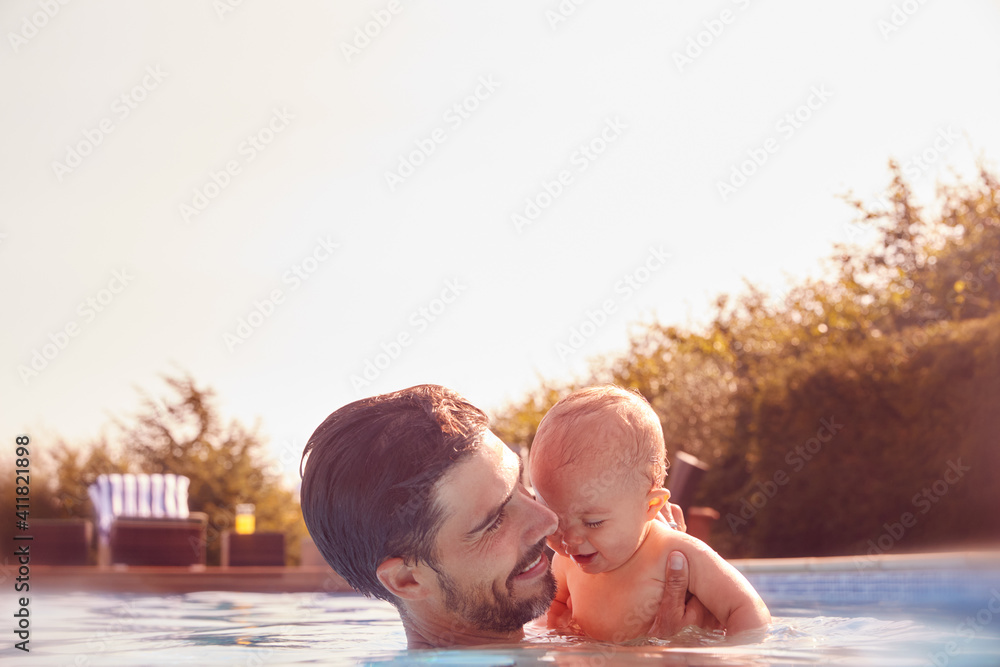 Father With Baby Daughter Having Fun On Summer Vacation Splashing In Outdoor Swimming Pool Father With Baby Daughter Having Fun On Summer Vacation Splashing In Outdoor Swimming Pool