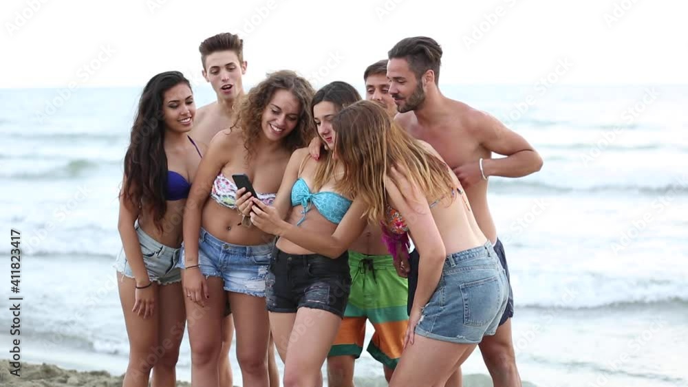Multicultural group of friends taking a selfie at beach - Young people together at seaside taking a photo with a mobile phone to share on social media - Lifestyle and friendship concepts Multicultural group of friends taking a selfie at beach - Young people together at seaside taking a photo with a mobile phone to share on social media - Lifestyle and friendship concepts