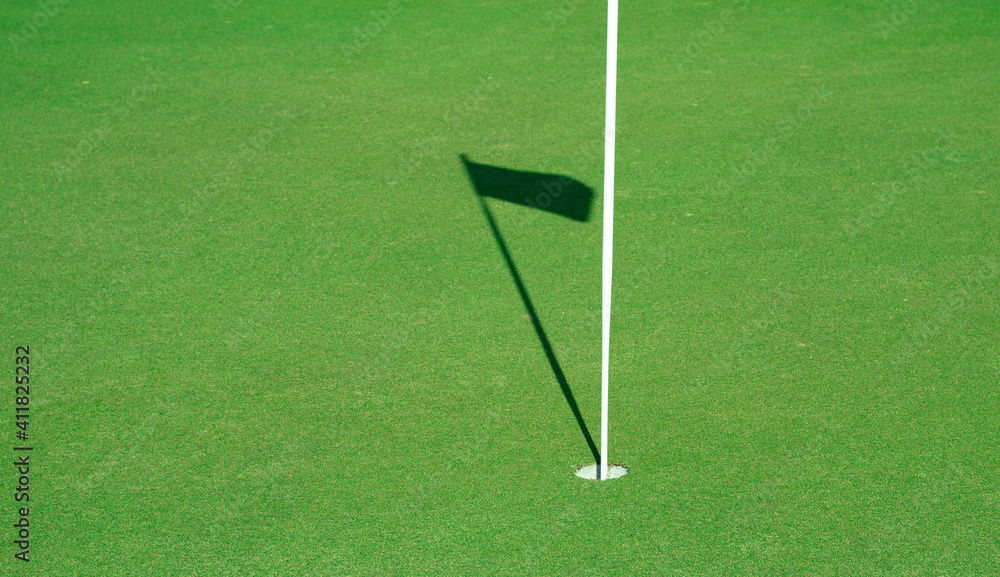 Golf hole with the shadow of the flag