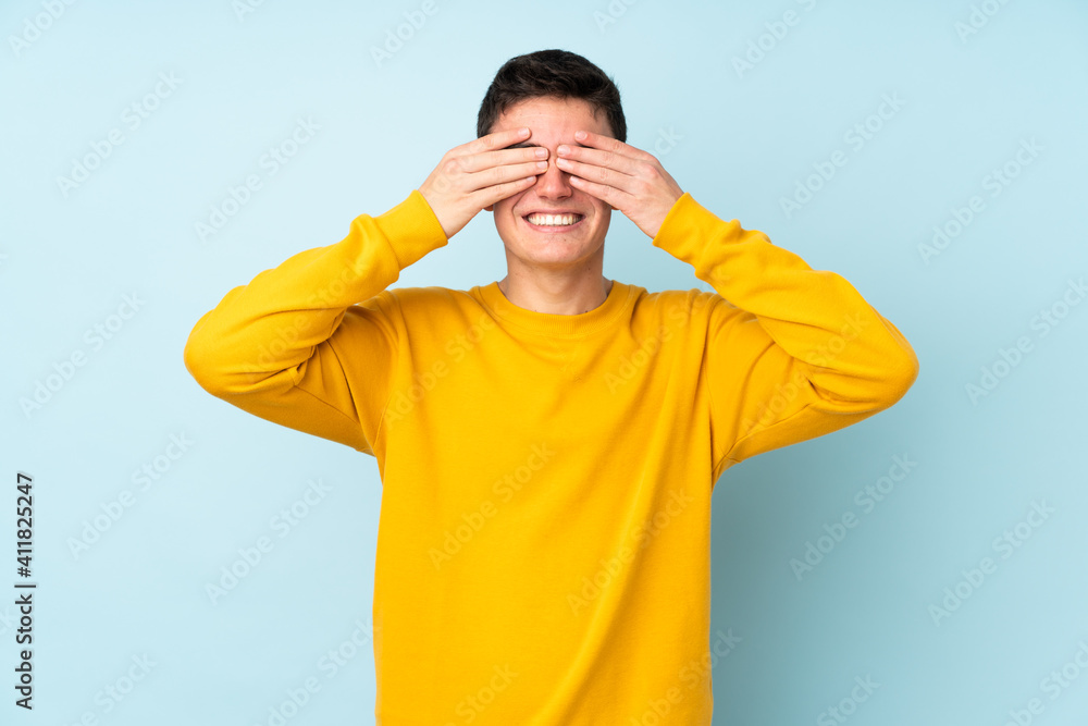 Teenager caucasian handsome man isolated on purple background covering eyes by hands Teenager caucasian handsome man isolated on purple background covering eyes by hands