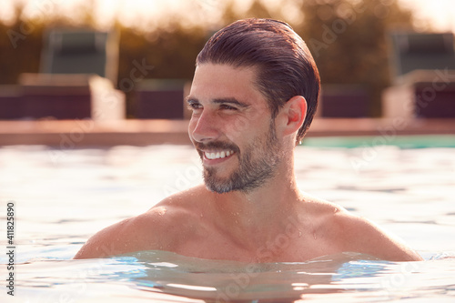 Smiling Man Relaxing On Summer Vacation In Outdoor Swimming Pool