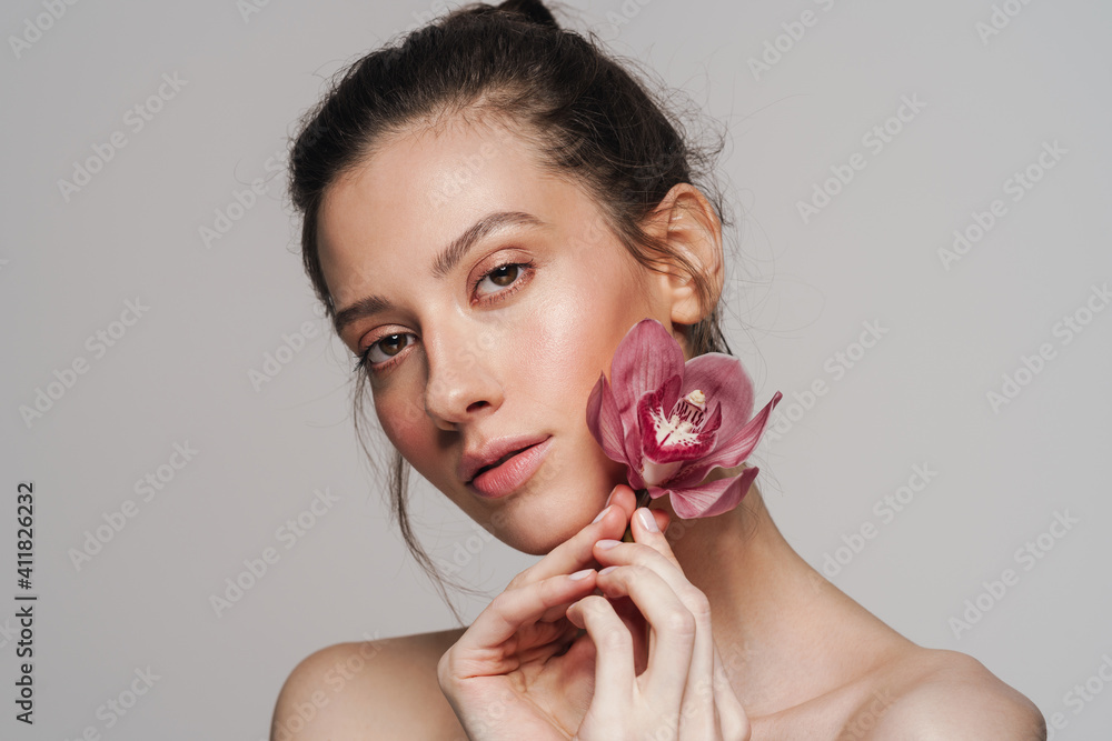 Sensual half-naked woman posing with orchid on camera Sensual half-naked woman posing with orchid on camera