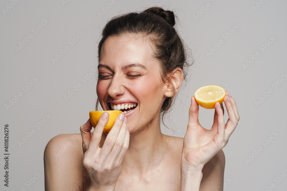 © Drobot Dean - Joyful half-naked woman laughing while eating lemon © Drobot Dean - Joyful half-naked woman laughing while eating lemon