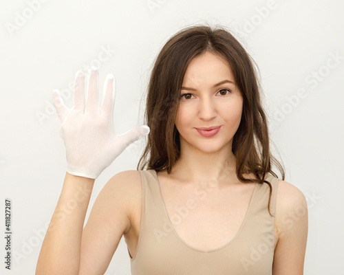 Young woman brunette wearing a white glove for hygiene 