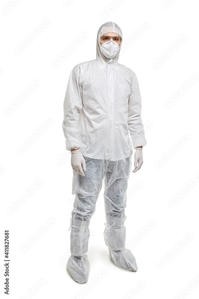 A male doctor in full-length chemical protection. He looks at the camera. White isolated background. A male doctor in full-length chemical protection. He looks at the camera. White isolated background.