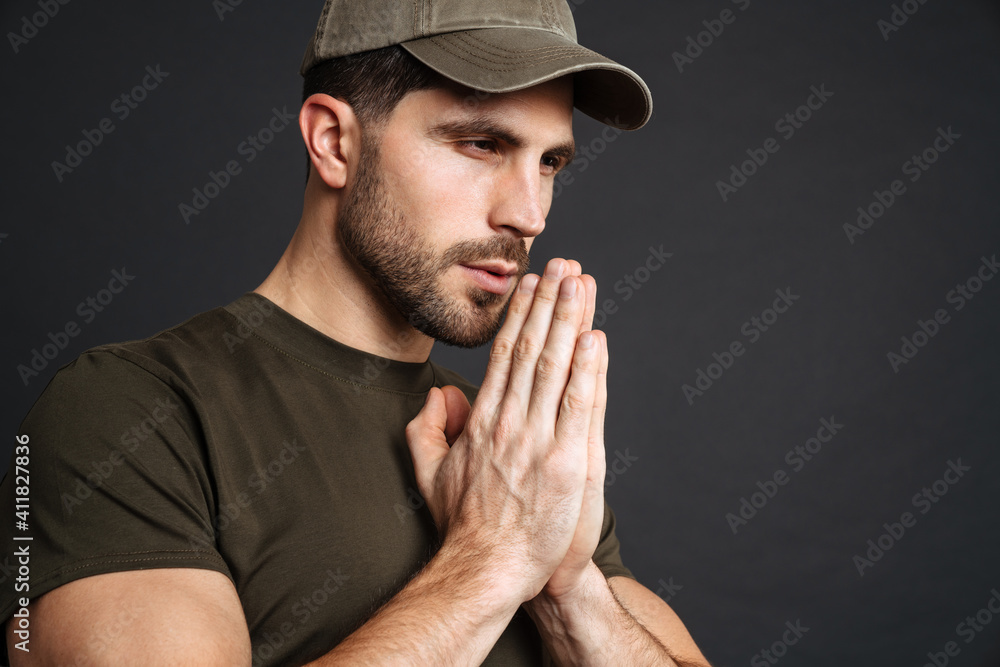 Focused masculine military man making praying gesture Focused masculine military man making praying gesture