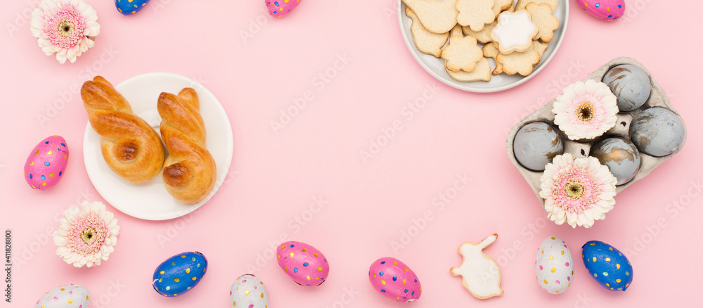 Homemade Easter bunny buns, sugar cookies, chocolate eggs, flowers on pastel pink background. Festive Easter breakfast concept. - obrazy, fototapety, plakaty 