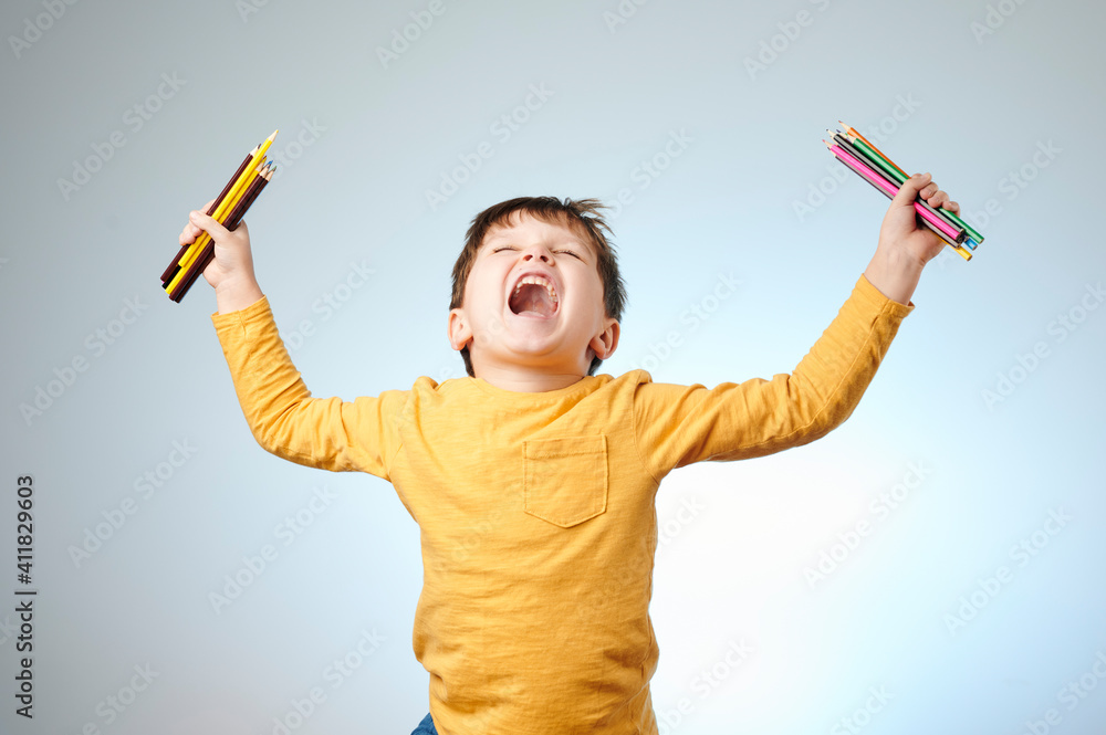 Happy boy with color pencils on light background. Happy boy with color pencils on light background.