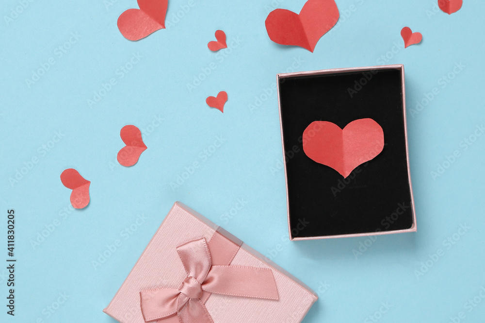 Gift box with Paper Cut Red hearts on blue background. Valentines day concept. Top view