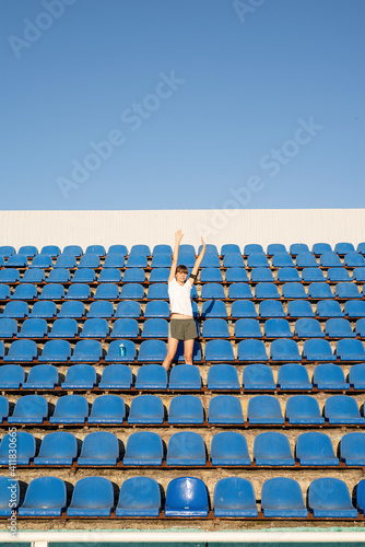 Teenage doing sports alone at the empty stadium photo