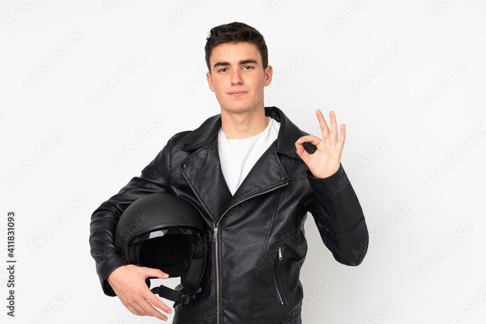 Man holding a motorcycle helmet isolated on white background showing an ok sign with fingers Man holding a motorcycle helmet isolated on white background showing an ok sign with fingers