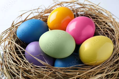 Bright painted eggs in nest, closeup. Happy Easter