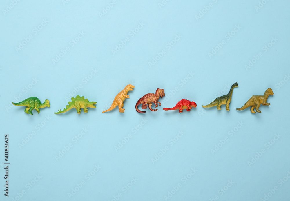 Fototapeta premium Toy dinosaurs on a blue background