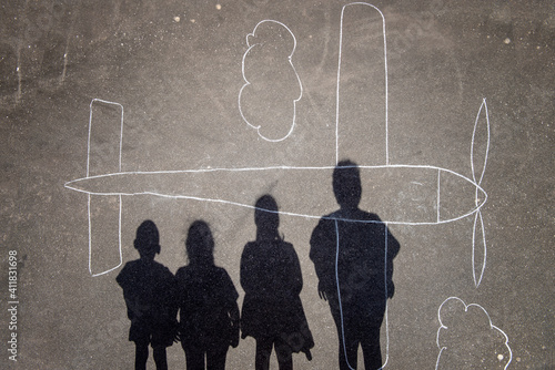 kids shadows over a chalk plane