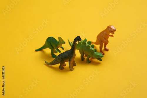 Fototapeta Naklejka Na Ścianę i Meble -  Toy dinosaurs on yellow background