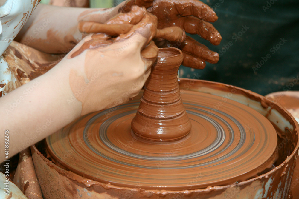 Fototapeta premium Potter shaping a ceramic pot on a pottery wheel