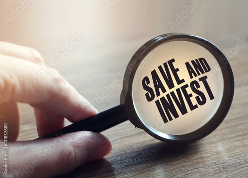 Save and invest under magnifying glass. Money saving trade and investment business concept photo