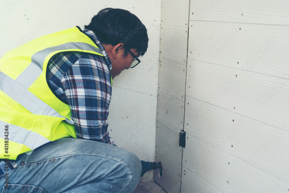 serious male plumber in working overall water pipe at home serious male plumber in working overall water pipe at home