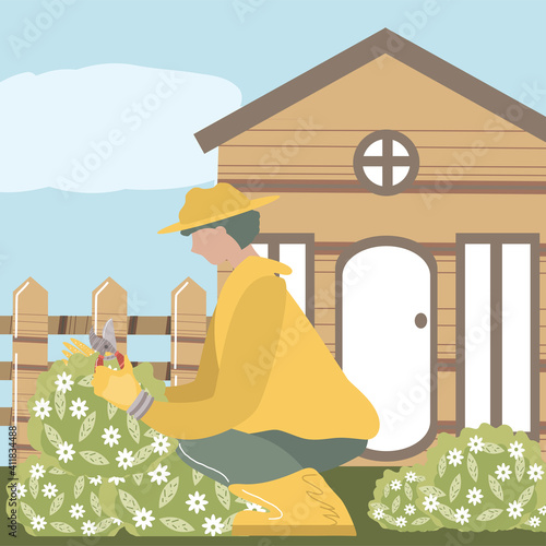home garden, gardener with scissors trimming flowers in front of the house