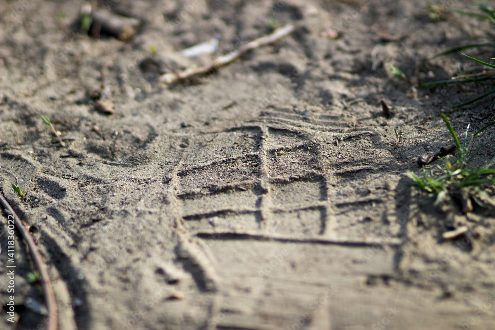 A footprint in the sand from a shoe or boot A footprint in the sand from a shoe or boot