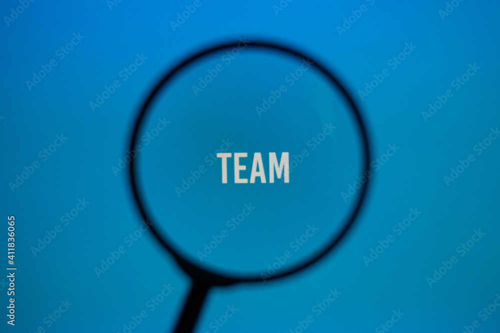 Word team on blue screen through magnifying glass. Word team on blue screen through magnifying glass.