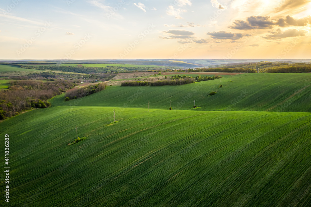 Aerial view of beautiful countryside with green rolling field in golden hour before sunset.. Aerial view of beautiful countryside with green rolling field in golden hour before sunset..