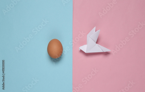 Origami dove and egg on a blue pink background. Spring, easter concept