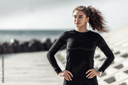 Curly sport woman in sportswear on urban beach. Healthy lifestyle