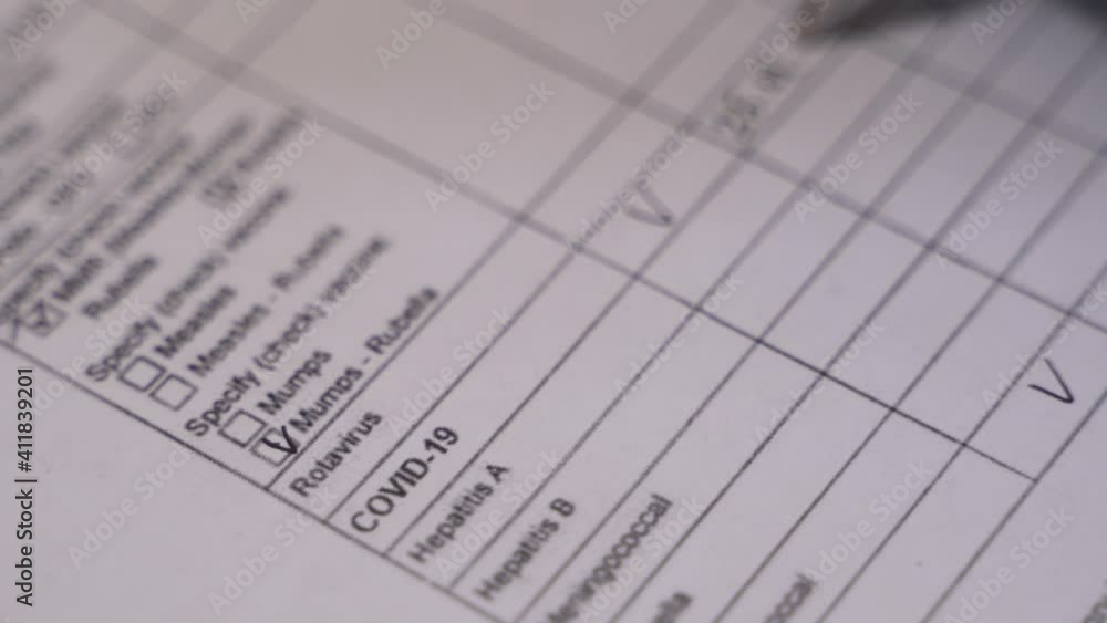 Close up of professional therapist hands signing medical document sitting at the desk in clinic. Doctor filling the vaccination documentation worksheet list during covid-19 pandemic. Close up of professional therapist hands signing medical document sitting at the desk in clinic. Doctor filling the vaccination documentation worksheet list during covid-19 pandemic.