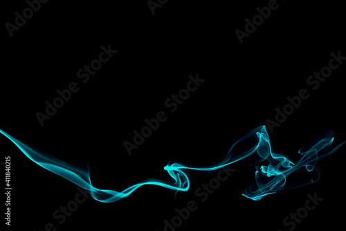 Abstract turquoise smoke swirl trail on black background.