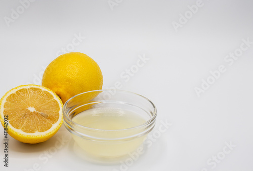Close up of a lemon, a slice of lemon, and a bowl with freshly squeezed juice and room for copy © Cynthia
